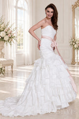 ivory strapless ruched mermaid wedding dress with tiered tulle skirt and waist bow side view
