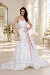 ivory strapless ruched mermaid wedding dress with tiered tulle skirt and waist bow front view