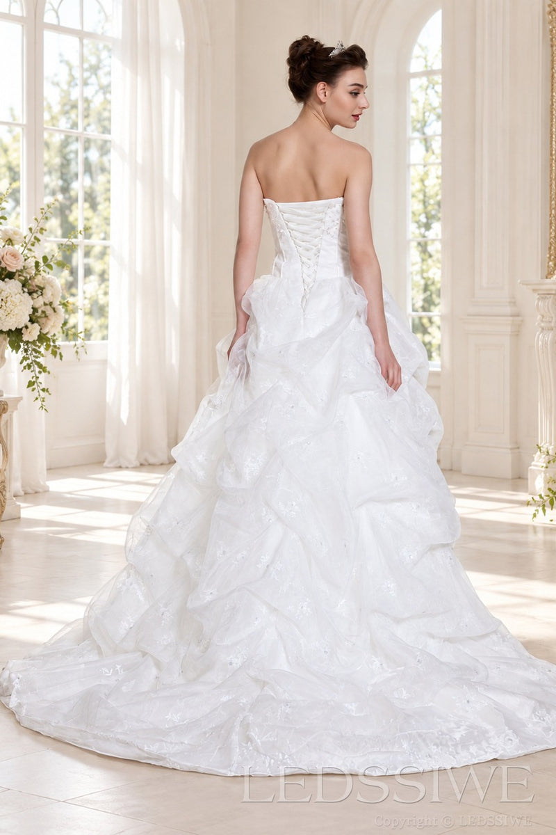 ivory strapless corset ball gown wedding dress with ruffled organza skirt back view